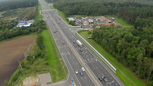 Contemporary Highway with Driving Cars Across Green Forest