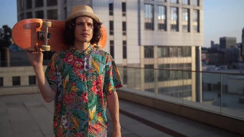 Young Man with Skateboard on City Rooftop
