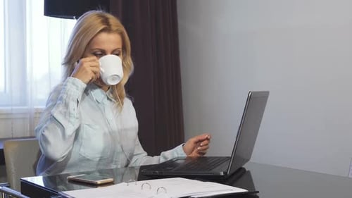 Smiling Girl Works Behind Her Computer and Makes a Video Call