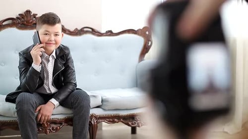 Smiling Boy Chatting on Cell Phone on Couch