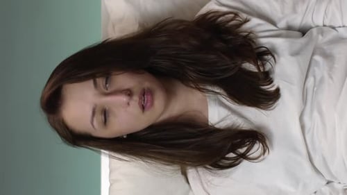 Une jeune fille malade à la verticale en pyjama dans son lit à la maison éternue constamment utilise des serviettes en papier