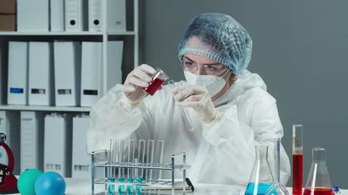 Scientist Carefully Pouring Liquid in Laboratory Experiment