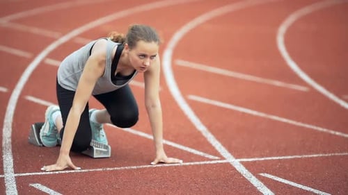 Female Runner Starting at the Stadium
