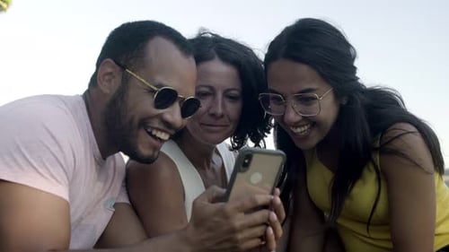 Friends Laughing Together at Content on Smartphone