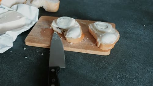 Sandwiches with Bread, Butter and Eggs on Wooden Board in Black Background