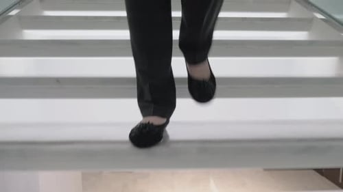 Woman Walking Down Modern White Marble Staircase
