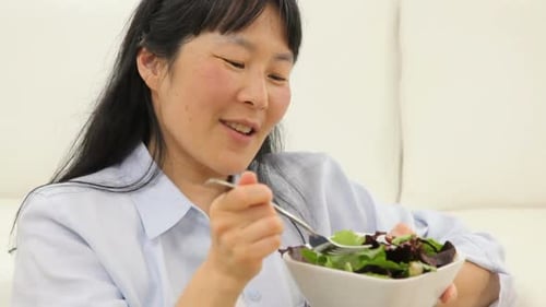 Woman Eating Healthy Salad While Relaxing at Home