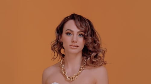 Glamorous Woman with Gold Jewelry and Wavy Hair