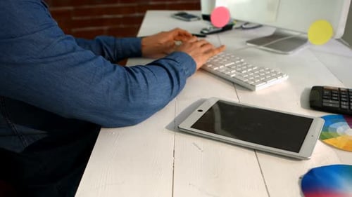 Männlicher Grafikdesigner verwendet digitales Tablet bei der Arbeit am Computer
