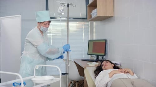 Nurse Preparing Female Patient for IV Therapy in Clinic