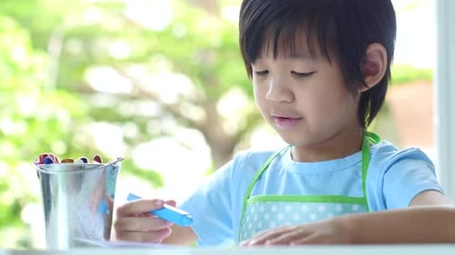 Young Child Drawing with Crayons at Home