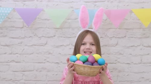 Cute Little Girl Smiling Giving Basket with Colorful Eggs on Easter