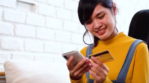 Young Woman Using Credit Card with Mobile Device