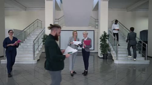 Businesswomen Discussing Documents in a Building Lobby