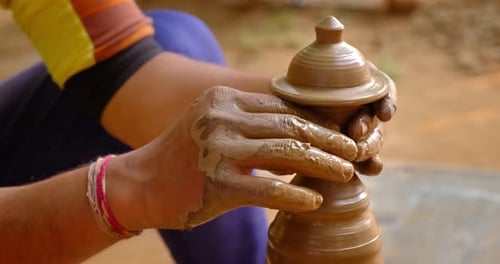 Mains habiles d'un potier façonnant l'argile sur Potter Wheel et sculptant un pot en argile, Shilpagram