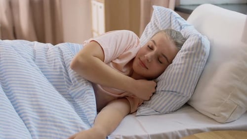 Young Woman Smiling and Stretching in Bed