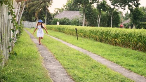 Little Girl Have Fun Running in the Sun Field