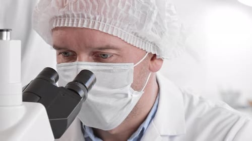 Adult Using Microscope in Medical Lab