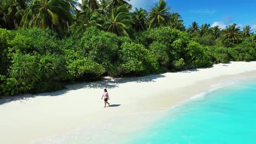 Woman happy and smiling on marine coastline beach trip by blue water with white sand background of t
