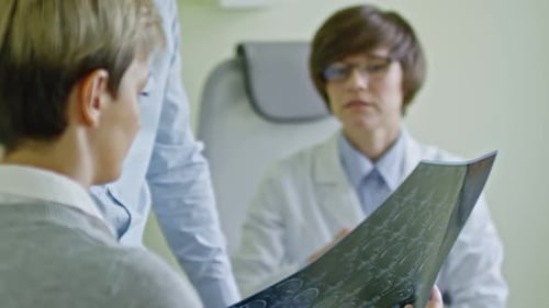 Doctor Reviewing Brain Scan with Patients in Office