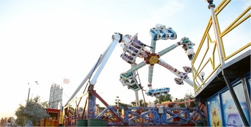Colorful Amusement Park Ride Spinning in Daytime