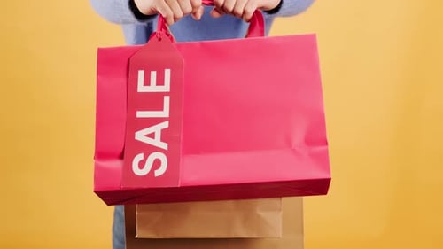 Colorful Shopping Bags with Sale Tag on Yellow