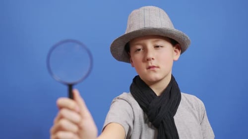 Boy Detective Investigating With Magnifying Glass