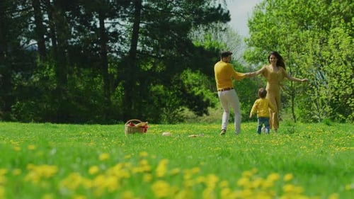 Happy Family Dancing in a Spring Meadow