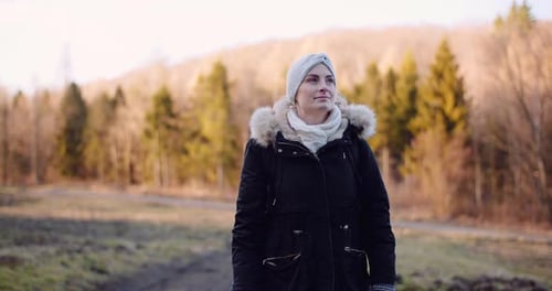 Woman Outdoor in Winter Coat Standing by Trees