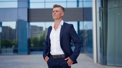 Confident Man in Suit Poses in Front of Building