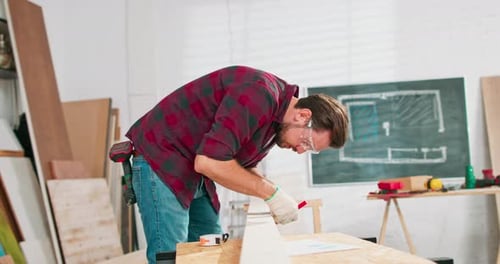 Portrait of Hardworking Professional Carpenter Holding a Ruler and Pencil While Measuring a Board in