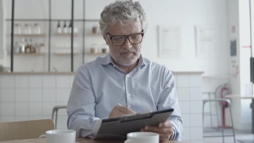 Man Working at Cafe Filling Out Form