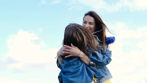 Loving Mother and Daughter Embracing with Blue Flowers
