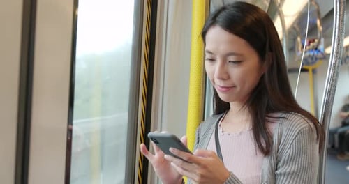 Femme utilisant un téléphone intelligent dans le compartiment du train