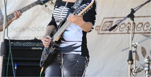 Woman Playing Electric Guitar on Stage