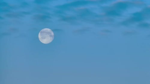 Moon Moving Across Blue Sky