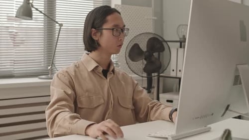 Asian Programmer Working in Office