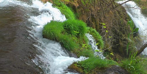 Picturesque Waterfall Flowing Over Mossy Rocks