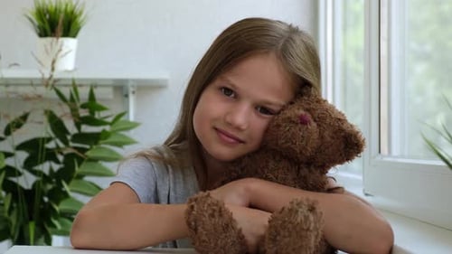 Portrait of a Little Girl with a Teddy Bear Looking at Camera