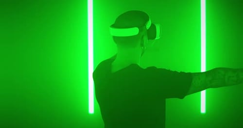 Amazed Guy Exploring Virtual Reality Near Colorful Lamps