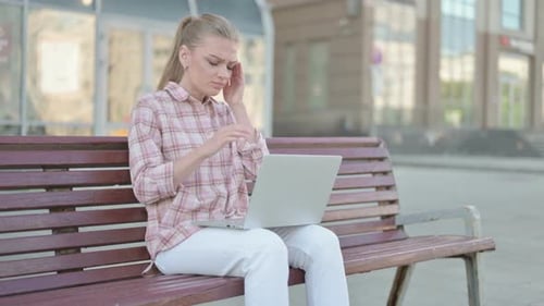 Woman With Headache Working on Laptop Outdoors
