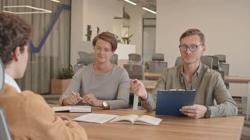 Interview Panel Assessing Job Candidate in Bright Office