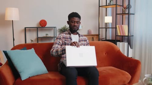 Man Works on Laptop in Comfortable Home