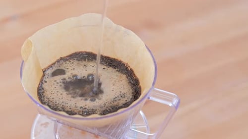 Water pouring to the coffee filter, making of hand drip coffee