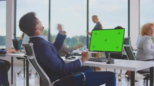 Enthusiastic Team Celebrates Success at Green Screen Computer
