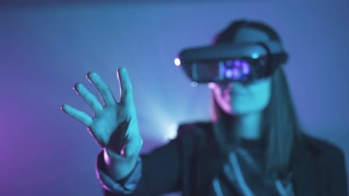 Woman Interacting with Virtual Reality Headset in Neon Studio