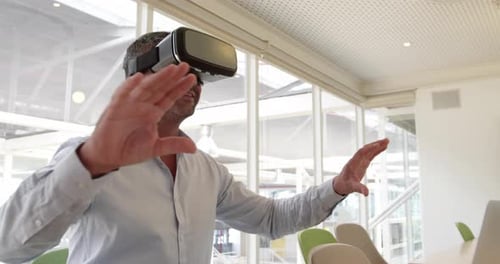 Businessman using virtual reality headset at desk in modern office 4 4k