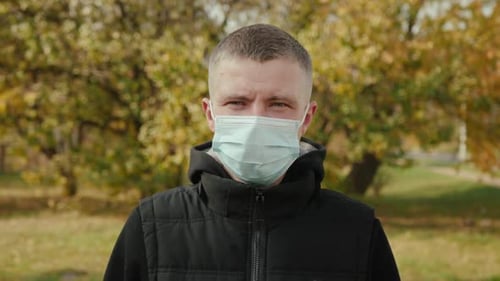 Adult Wearing Face Mask Outdoors During Autumn