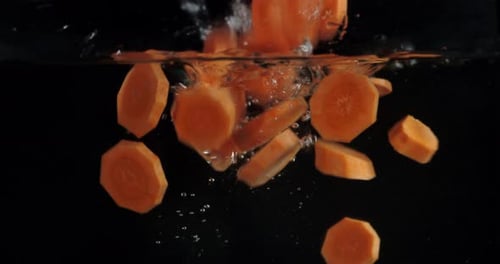 Karottenstücke mit Luftblasen unter Wasser fallen lassen.