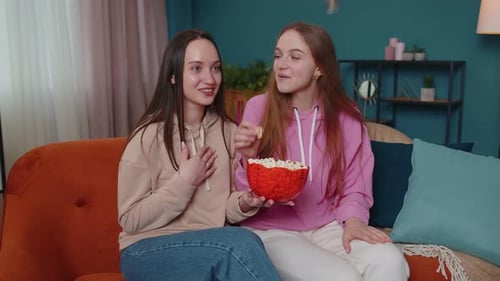 Two Friends Watching TV and Eating Popcorn